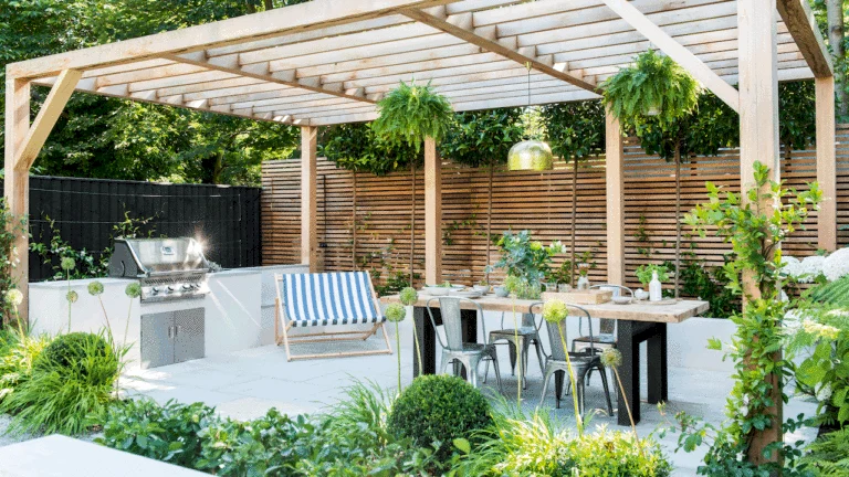 UK garden designed with Mediterranean-style elements including drought-tolerant plants, terracotta pots, stone walls, and gravel pathways.